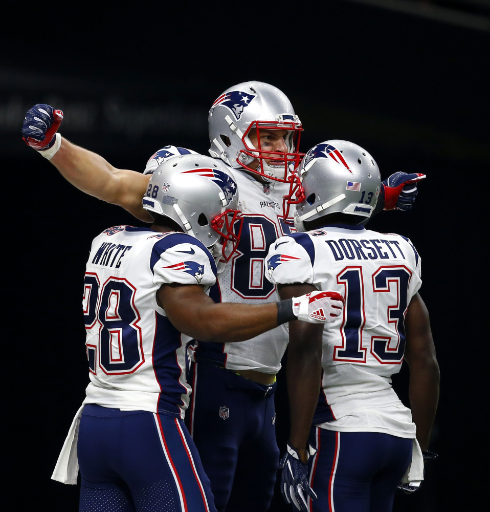 New England Patriots tight end Rob Gronkowski celebrates his touchdown with running back James White (28) and wide receiver Phillip Dorsett (13) in the first half Sunday against the Saints.