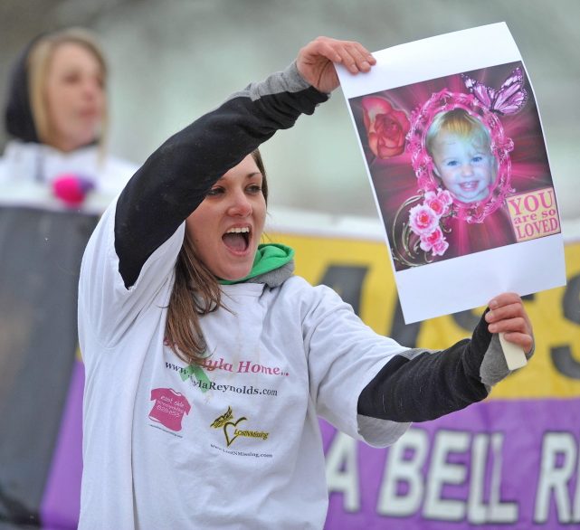 Trista Reynolds, mother of missing toddler Ayla Reynolds, holds a picture of her daughter in January 2014 at the Colby Circle and College Avenue intersection in Waterville during a rally. Trista Reynolds is seeking a formal court declaration that Ayla is dead so a wrongful death lawsuit can be pursued against Ayla's father, Justin DiPietro.
