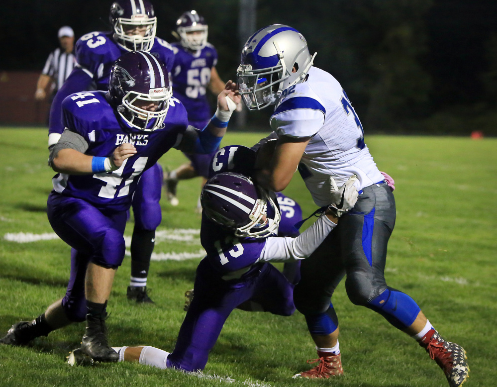 Marshwood's Ian Parmley tackles Lawrence ball carrier Tyler Larouche during a Class B game Friday night.
