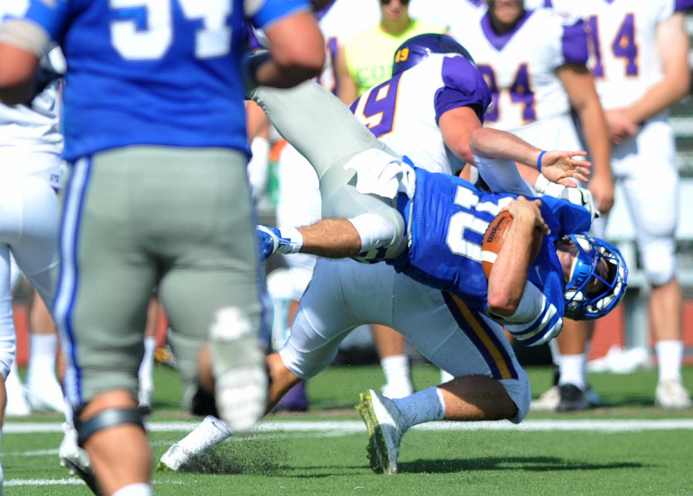 Colby College quarterback Jack O'Brien (10) gets hit  by Williams College's Jameson DeMarco (49) as runs for the first down Saturday at Colby College in Waterville.