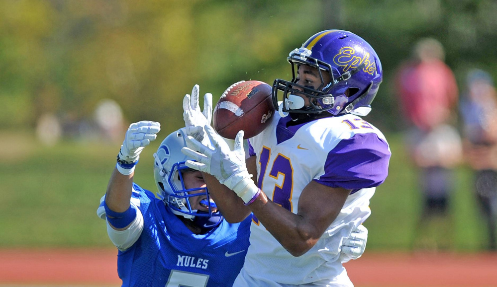 Williams College receiver Justin Nelson (13) makes a catch as Colby College's Patrick Yale (5) defends Saturday at Colby College in Waterville.