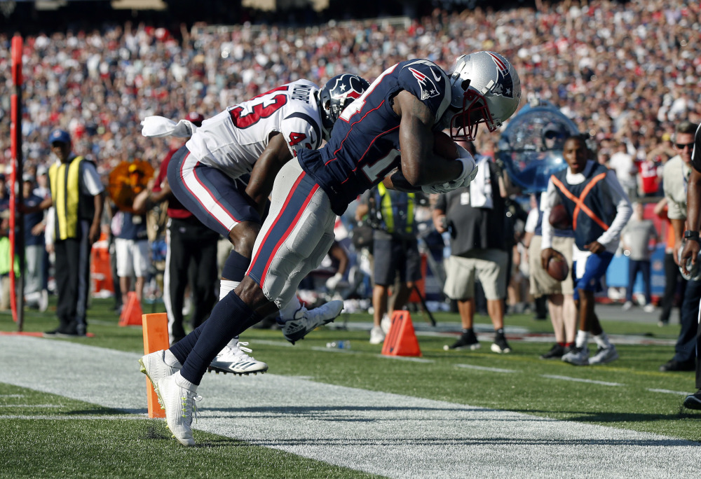 New England Patriots wide receiver Brandin Cooks, right, drags his toes as he makes the game-winning catch in the end zone for a touchdown in front of Houston Texans safety Corey Moore, left, during the second half Sunday in Foxborough, Massachusetts.