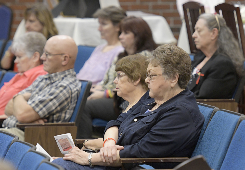 Families of homicide victims listen to speeches Monday during the Maine Day of Remembrance for Murder Victims in Augusta.