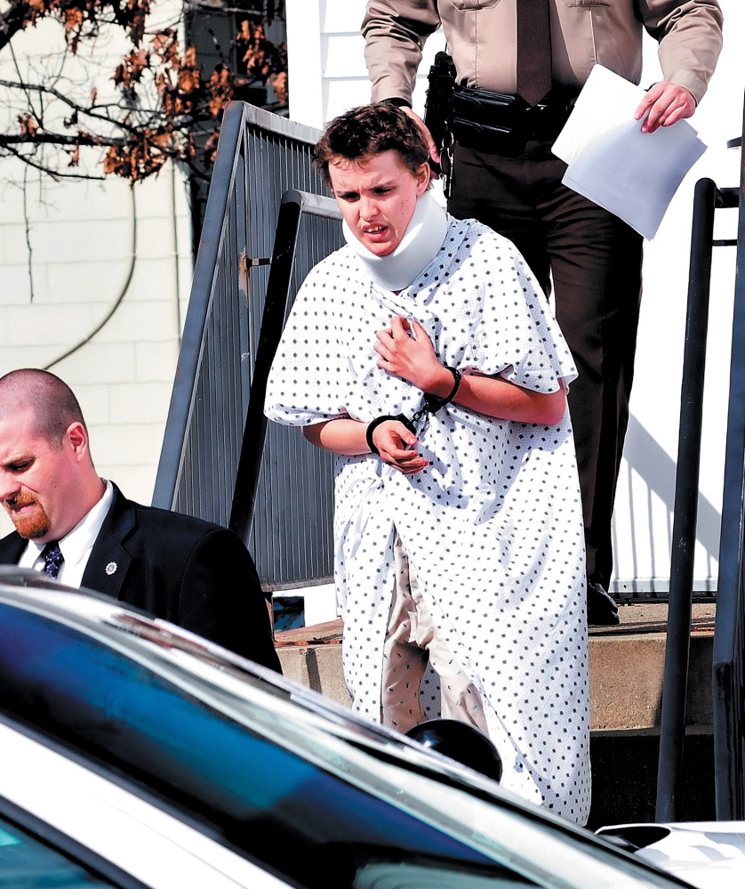 Wearing a hospital gown and neck brace from injuries suffered in a car crash, Zachary Wittke exits the Franklin County District Court in Farmington on Oct. 15, 2013, after a hearing on charges of eluding police, passing a roadblock and aggravated criminal mischief.