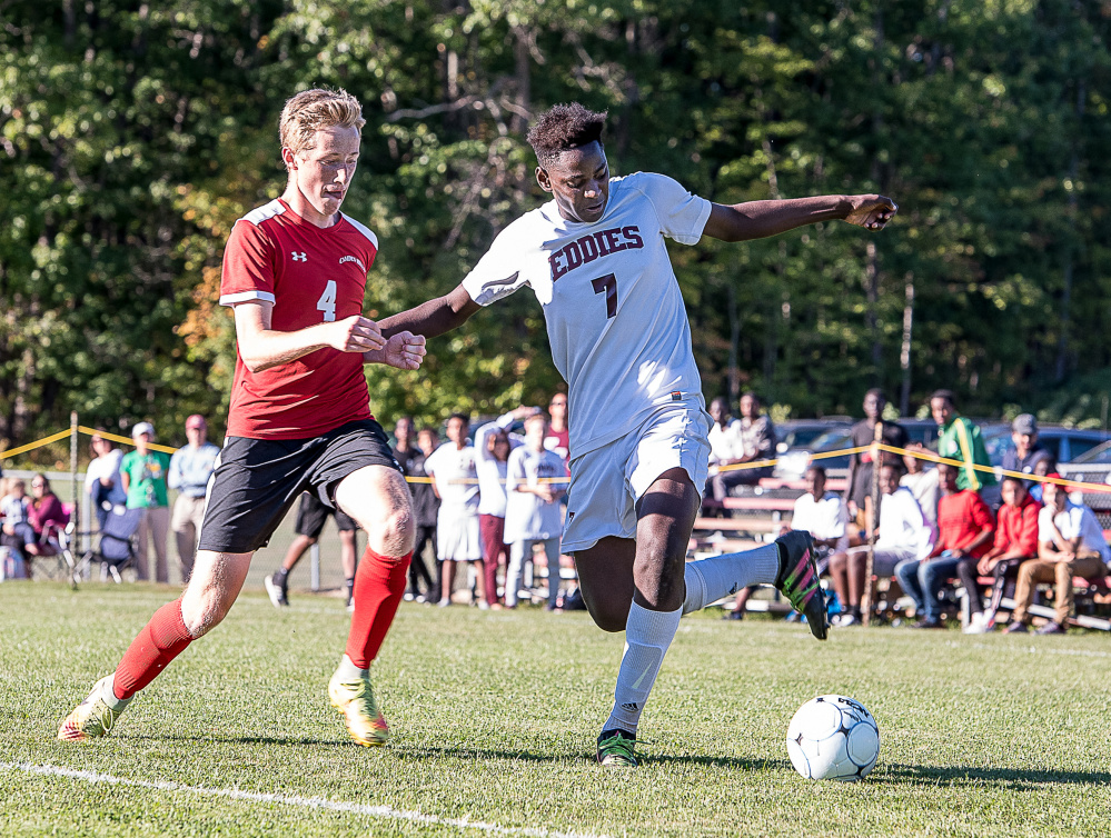 Edward Little's Joel Musese  uses some footwork to keep the ball in bounds as Camden Hills' Max Moore keeps the pressure on during Thursday afternoon's soccer game in Auburn.