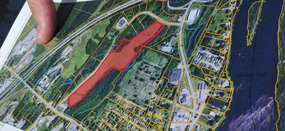 Garvan Donegan, of the Central Maine Growth Council, points to an aerial map Wednesday showing the area of the closed landfill on Eskelund Drive in Fairfield, where Gizos Energy proposes to build an array of solar power collectors.