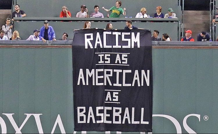 A banner is unfurled over the left field wall during the fourth inning of Wednesday night's game at Fenway Park.