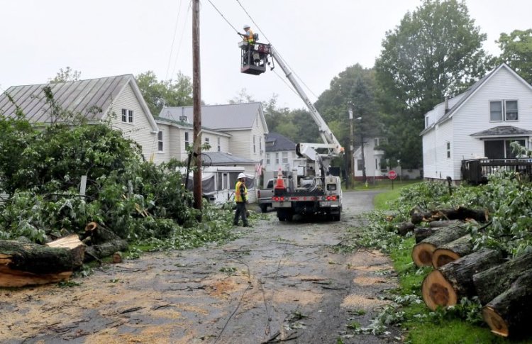 Workers with Spectrum repair cable lines Wednesday morning after a large limb from a maple tree toppled cable and phone lines and damaged property on both sides of Preble Street in Fairfield during a storm Tuesday evening. Fairfield Public Works crew helped with the cleanup. 