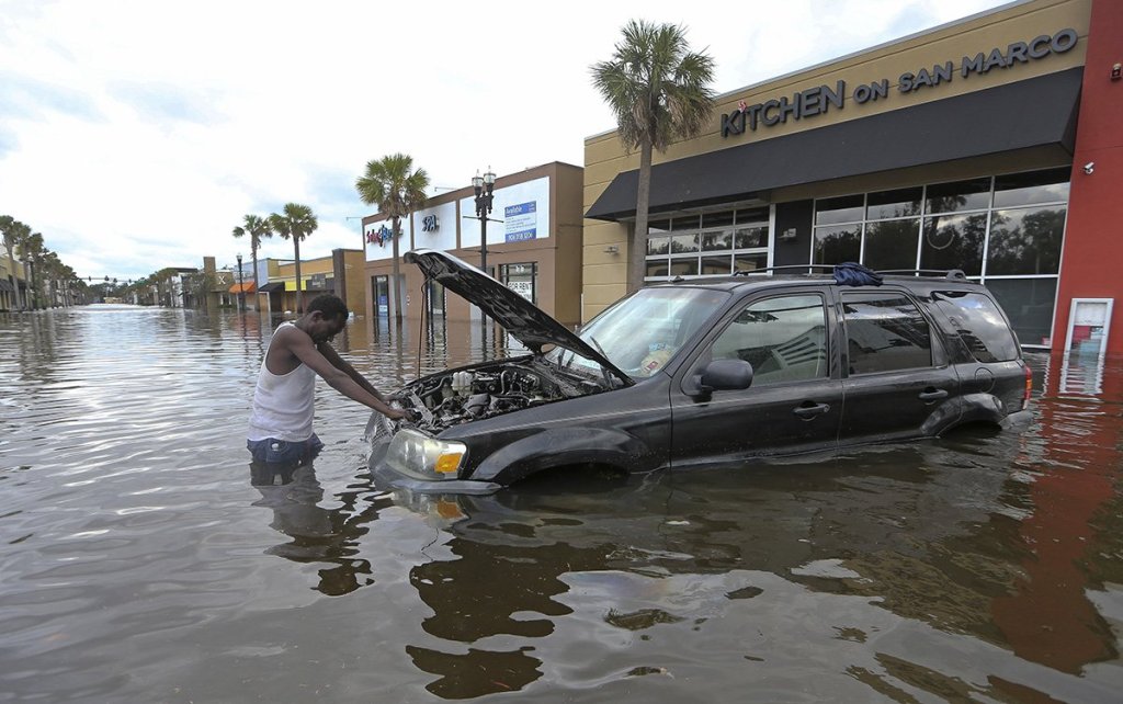 John Duke tries to figure out how to salvage his flooded vehicle in the wake Hurricane Irma, Monday in Jacksonville, Fla. 