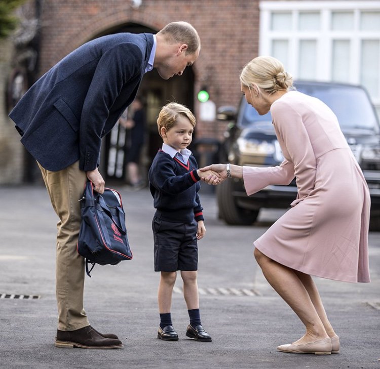 Prince William accompanies Prince George as he is greeted by the head of the lower school as he arrives for his first day of school in  London on Thursday.
