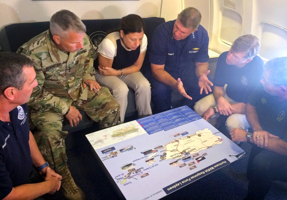 Acting Homeland Secretary Elaine Duke, center, is briefed on the Hurricane Maria response during a flight to Puerto Rico on Friday. President Trump on Thursday cleared the way for more supplies to head to Puerto Rico by waiving restrictions on foreign ships delivering cargo to the island.