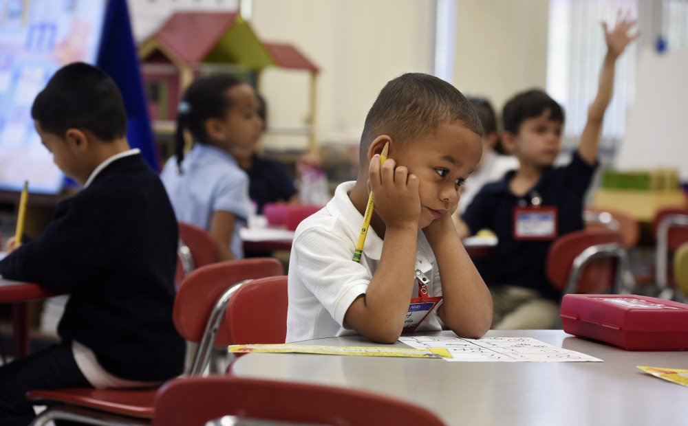 Elionet Saez Martin of Puerto Rico works at his desk in his class at Chamberlain Elementary School in New Britain, Conn., on Friday. His mother put him and his 9-year-old brother, Eliot, on a plane to be with their grandfather.