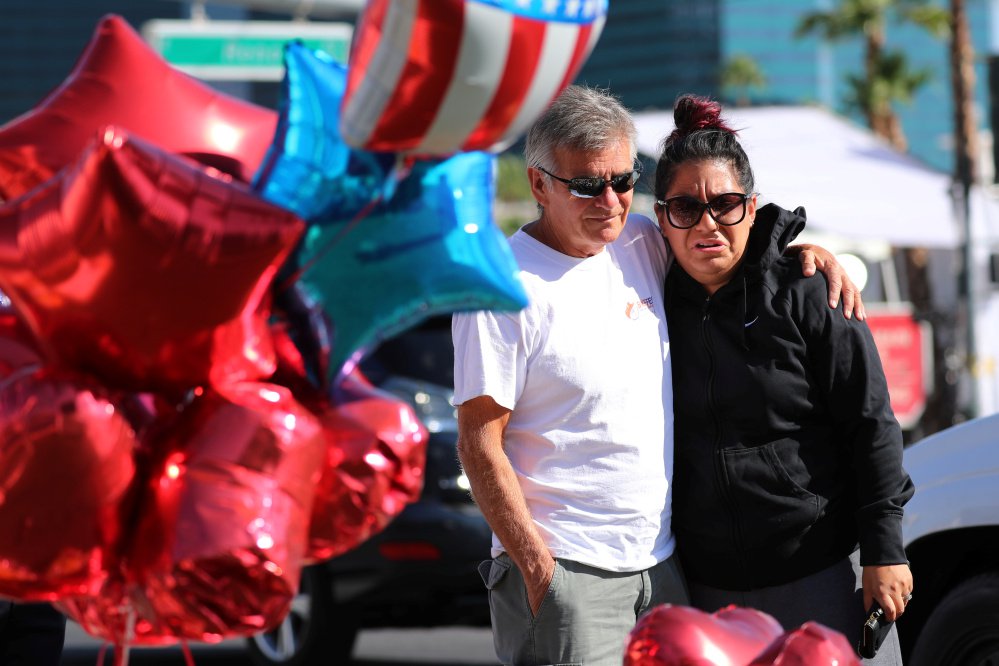 A couple hug after stopping their car to view a makeshift memorial in Las Vegas to the victims of the mass shooting.