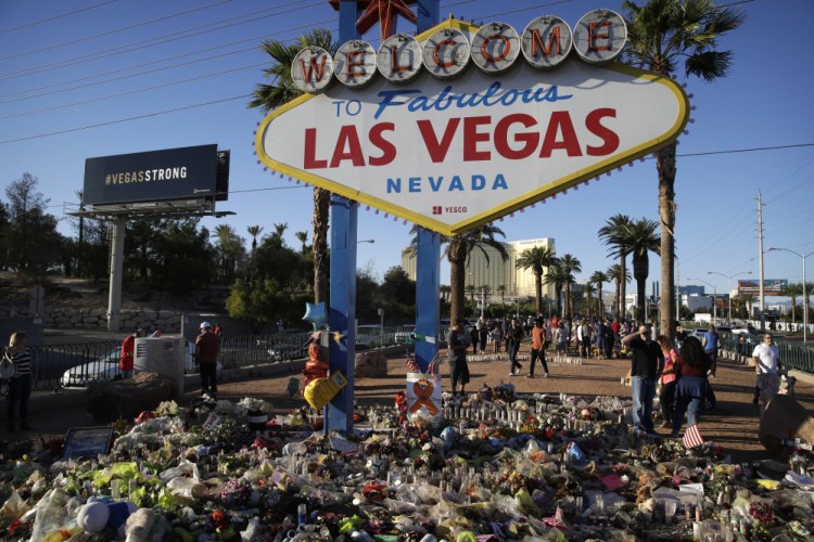 Flowers, candles and other items surround the famous Las Vegas sign at a makeshift memorial for victims of the mass shooting Oct. 1. Stephen Paddock opened fire on an outdoor country music concert, killing 58 and injuring hundreds.