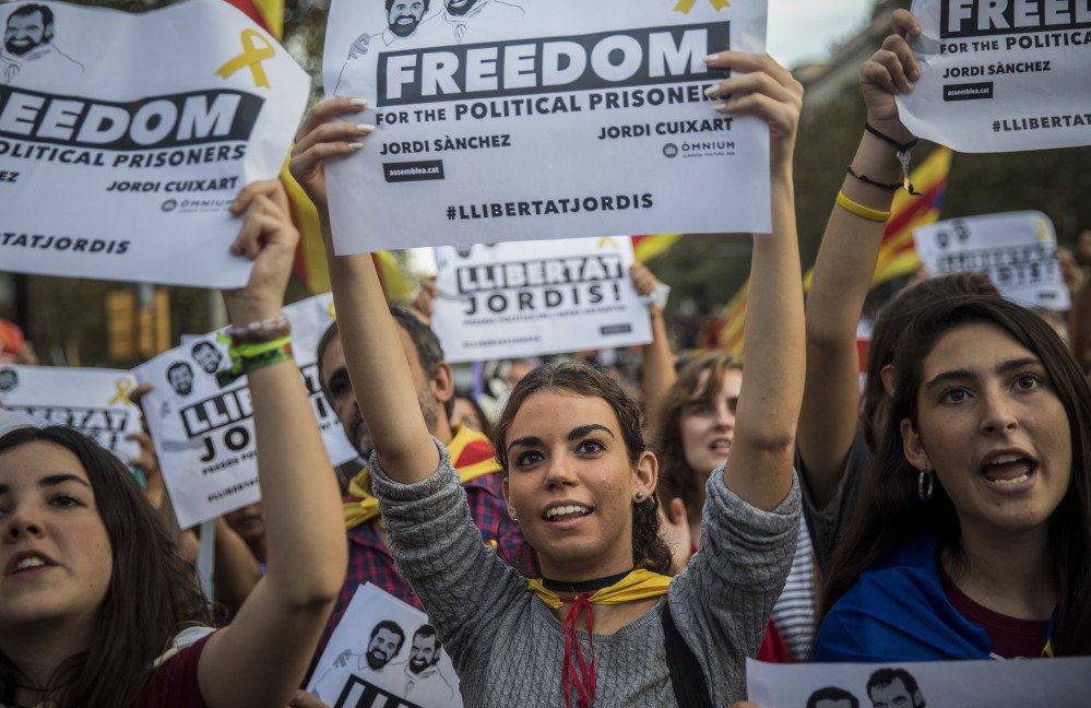 Demonstrators hold up signs during a march to protest the latest government move in Barcelona, Spain, on Saturday.