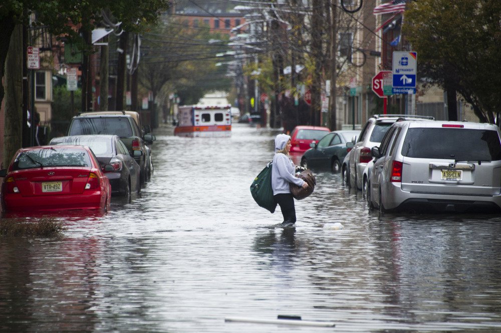 A woman walks through floodwaters in Hoboken, N.J., on Oct. 30, 2012, the day after Superstorm Sandy struck the coasts of New York and New Jersey.