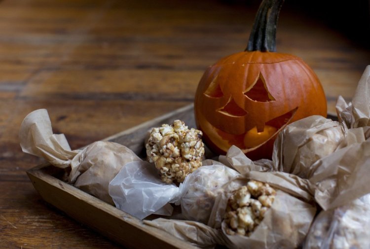 Honey, peanut butter and chocolate popcorn balls are a great Halloween treat to munch on while you are handing out candy to kids.