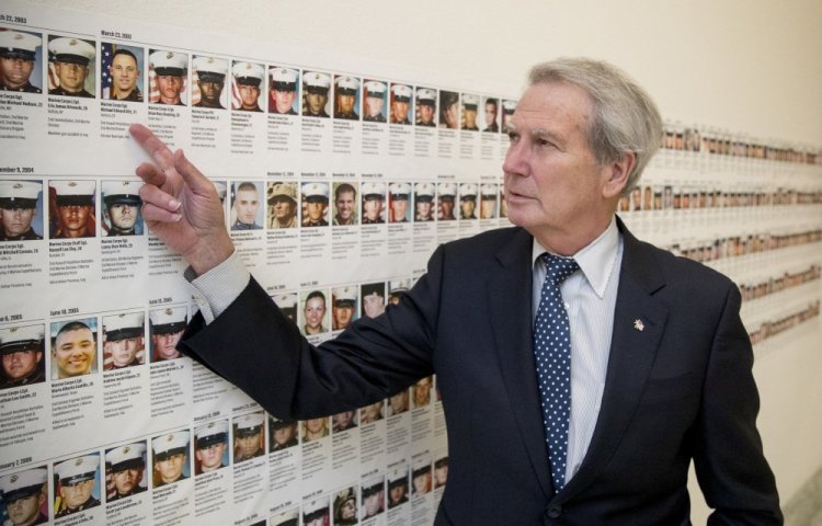 Rep. Walter Jones, R-N.C., points at a photo of Marine Sgt. Michael Edward Bits, the first military funeral he and his wife attended, and one of the many pictures of fallen soldiers along a hall leading to his office on Capitol Hill.