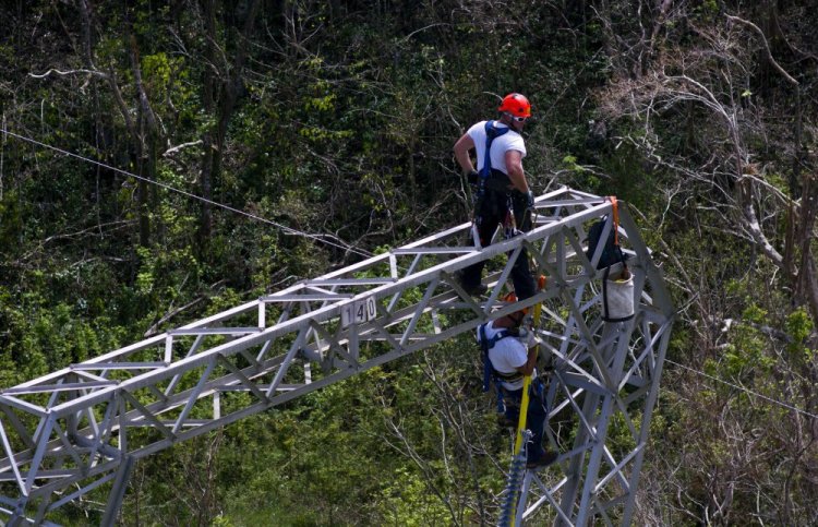 Whitefish Energy Holdings workers restore power lines damaged by Hurricane Maria in Barceloneta, Puerto Rico. FEMA says it had no involvement in the decision to award a $300 million contract to help restore Puerto Rico's power grid to a tiny Montana company in Interior Secretary Ryan Zinke's hometown.