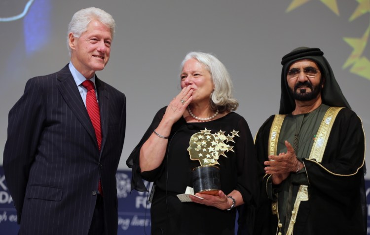 Educator Nancie Atwell responds to applause after receiving the first Global Teacher Prize. With her on stage in Dubai are former President Bill Clinton and Sheikh Mohammed bin Rashid Al Maktoum, the ruler of Dubai.