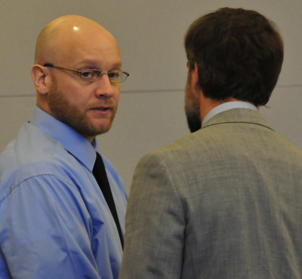Murder defendant Robert Burton, left, speaks with attorney Hunter Tzovarras on Monday during his trial at the Penobscot Judicial Center in Bangor before taking the stand in his own defense.