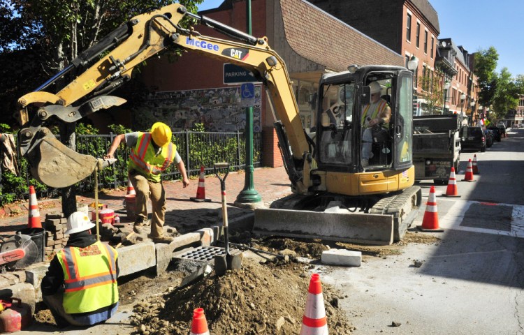 A crew from Steven A. McGee Construction installs a new granite curb Tuesday on Water Street in Gardiner.