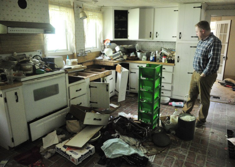 Richard Fortin, librarian at Charles M. Bailey Public Library, looks at the kitchen of 36 Bowdoin St. on Tuesday in Winthrop. The building is one of two homes that are expected to be demolished to make way for a parking lot.