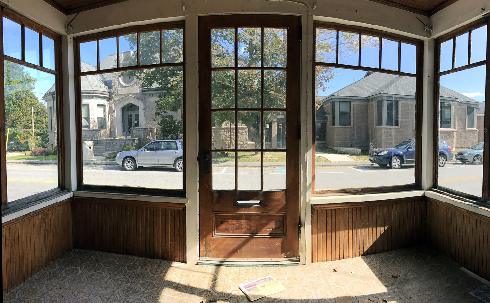 Charles M. Bailey Public Library is seen framed through front porch of 40 Bowdoin St. on Tuesday in Winthrop. The Town Council voted Monday to allow the library to tear down the building to make room for a parking lot.