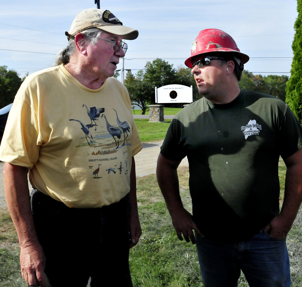 Phil Frizzell, left, of the Palermo Community Center, speaks with driller Chad Grignon, of Pine State Drilling, who was finishing drilling a new well for the center.