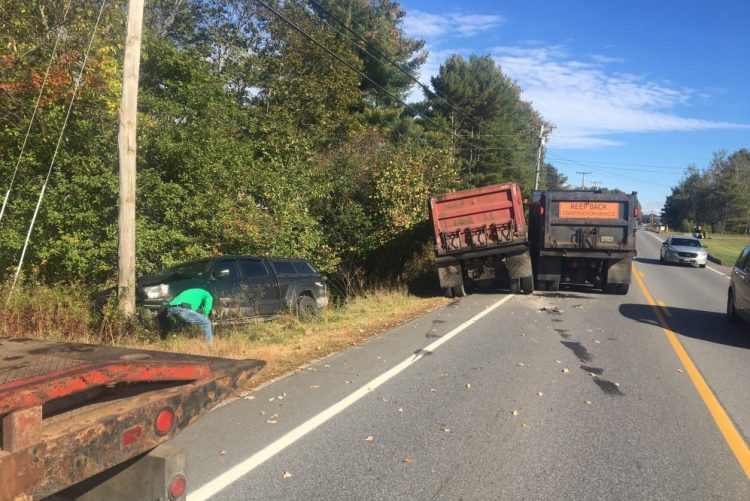 Two dump trucks got stuck together when they veered into the oncoming lane one after the other to avoid a trash truck in their lane. In the process the first forced the driver of a Toyota pickup off the road and into a utility pole.