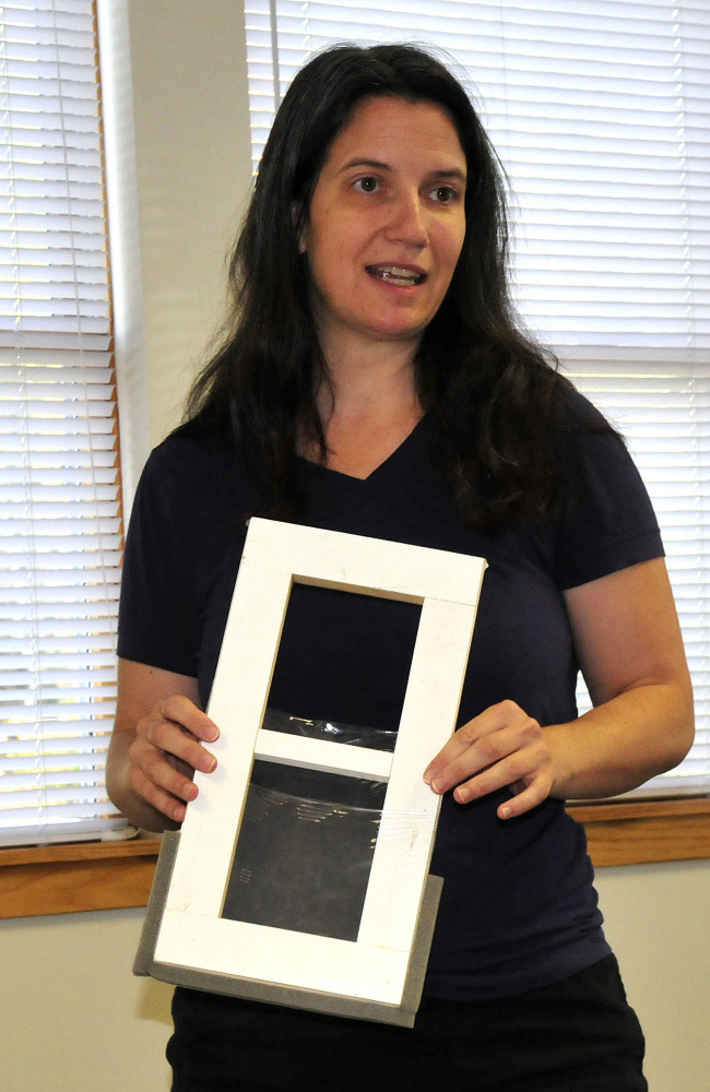 Laura Seaton, a representative of the WindowDressers program, shows a window insert on Wednesday that can reduce energy consumption to members of the Vassalboro FAVOR committee.