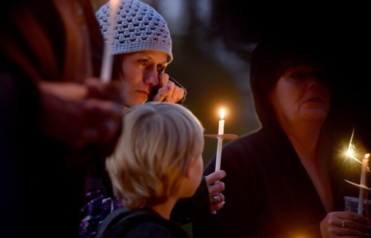 Jessica Hainer, who described herself as a victim of domestic violence, becomes emotional Thursday as she stands with her daughter Shayla, 8, during a domestic violence awareness candlelight vigil at the gazebo at Coburn Park on Water Street in Skowhegan.