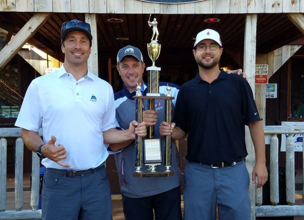 Seth Wescott, left, presents a trophy to members of the winning team from Darlings, Adam Orser and Ashley Fifield.