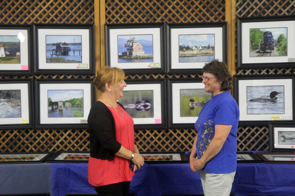 Manchester resident Christina Rao chats with long-time friend, Mt. Vernon photographer Beverly Olson during an "Art on the Courts" fundraiser in Augusta on Sunday to benefit Maine General's OutPatient Plus Program and the Kennebec Valley Tennis Association. Olson said it was Rao, who she has known since high school, who told her about the event.