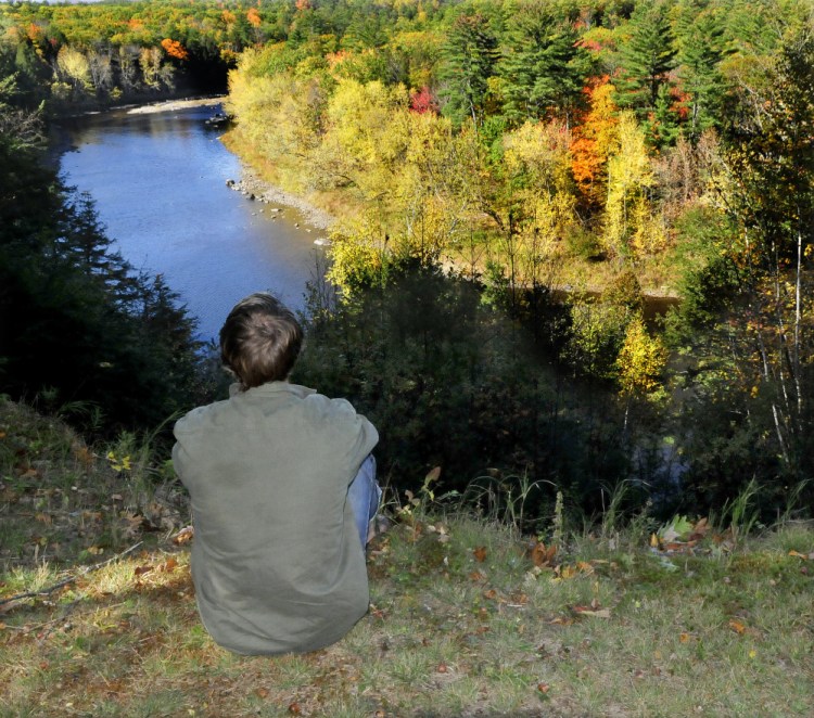 A Mercer resident who chose to remain anonymous looks down on the Sandy River from his home on Monday. He was rescued by firefighters from Skowhegan and Norridgewock after he injured his ankle with an ax. It took about 300 feet of rope and many hands to haul him up from the riverside to the top of the steep embankment in a Stokes basket on Sunday.