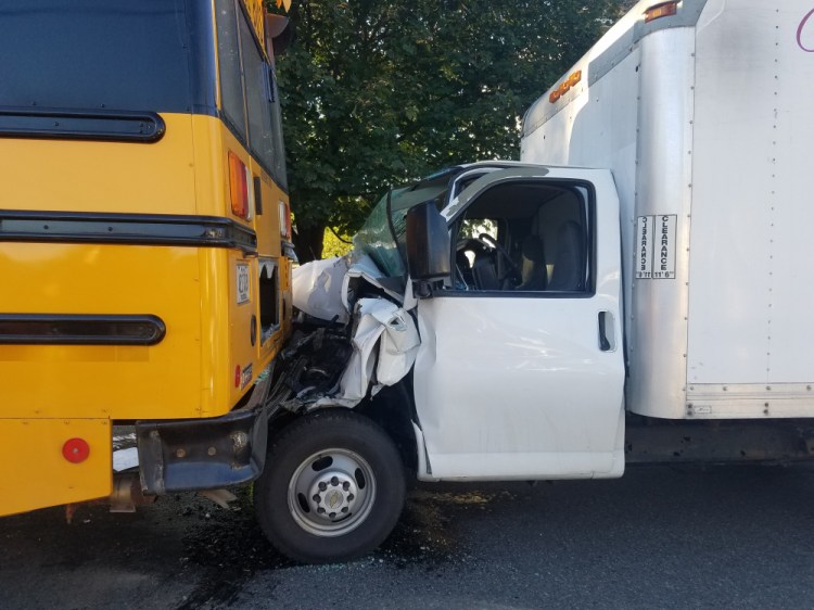 Sun glare blinded the driver of a box truck that crashed into the rear of a school bus Tuesday in Waterville with 13 children on board the bus.