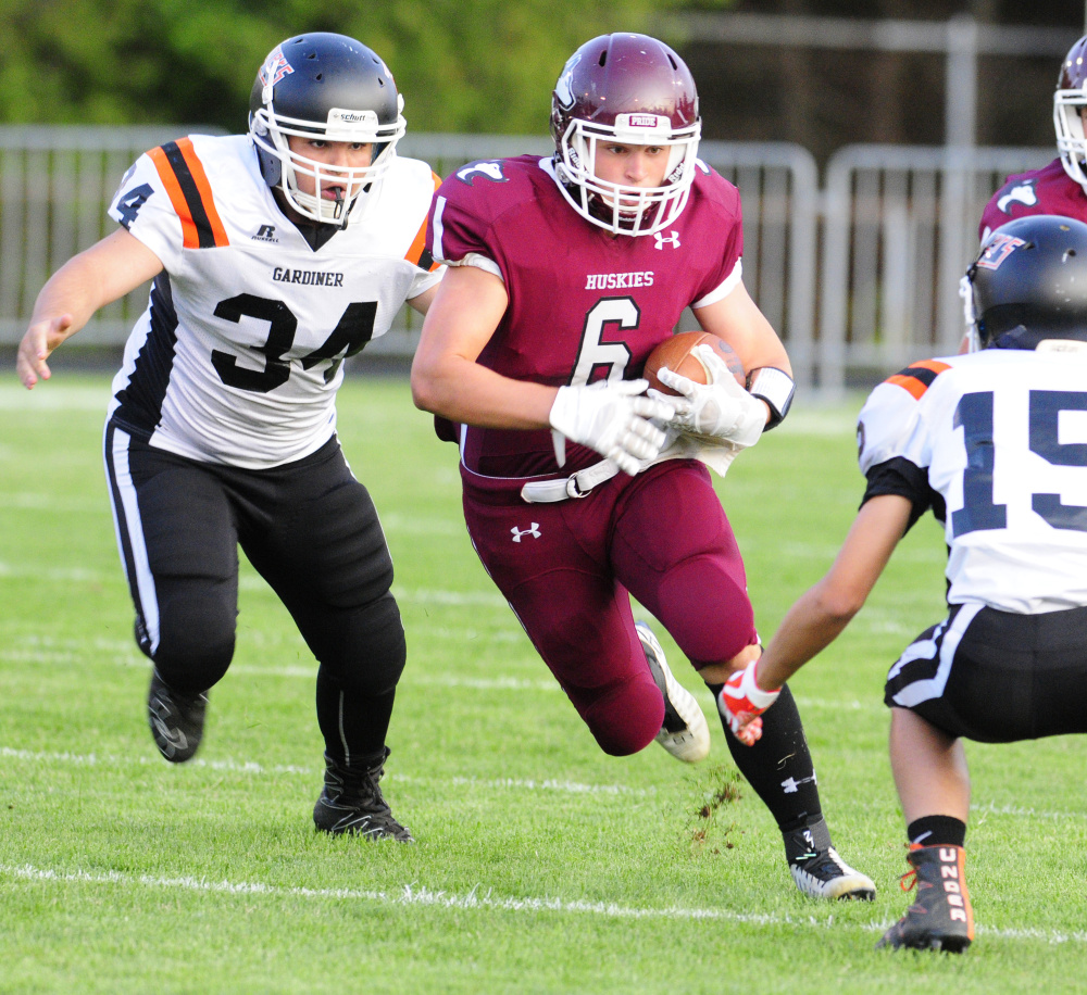 MCI's Adam Bertrand, center, gets chased down by Gardiner's Dylan Spencer, left, and Dimitri Paradis during an exhibition game Aug. 25 at Hoch Field in Gardiner.