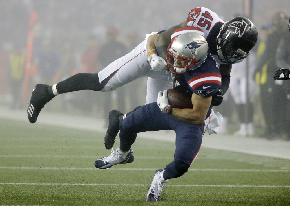 Atlanta Falcons linebacker Deion Jones tackles New England Patriots wide receiver Chris Hogan during the second half Sunday in Foxborough, Massachusetts.
