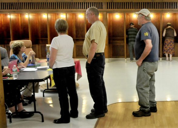 Residents in the 10 towns that make up the RSU 9 district will vote for the fourth time on a school budget on Tuesday. Farmington residents wait in line to obtain ballots for the school budget vote at the Community Center in Farmington on Sept. 11.