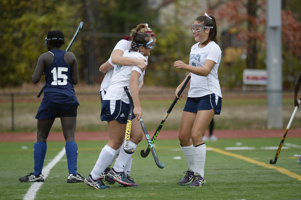 From left, York's Sydney Bouchard, Barbara Conradt and Cassandra Reinertson celebrate after Conradt scored during the Class B South final against Poland on Tuesday in Saco.
