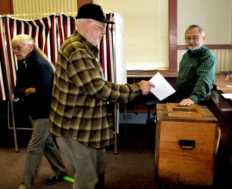 New Sharon resident Bob Neal casts his ballot Tuesday in the Regional School Unit 9 school budget referendum as warden Forrest Bonney watches. Mercy Hanson had just cast her ballot. Bonney said turnout was light in early afternoon. "I call it voter fatigue," Bonney said referring to the fourth vote on the budget.