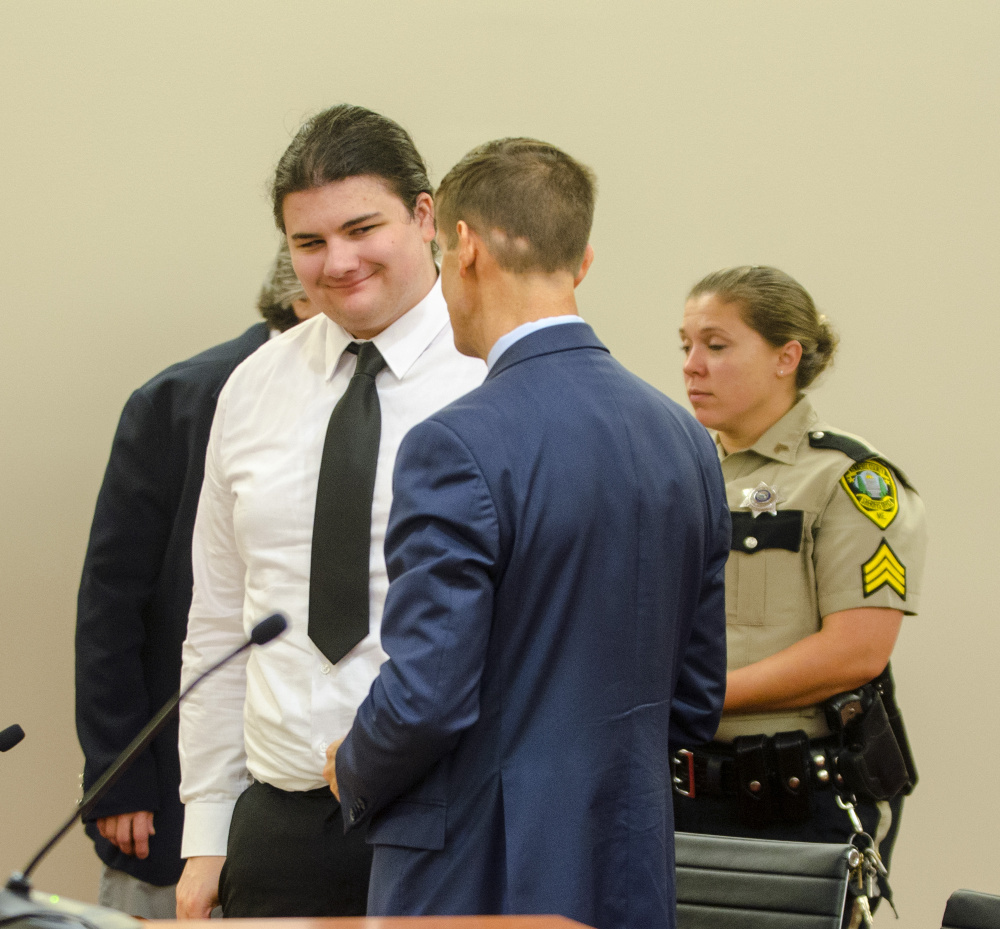 Andrew Balcer, left, smiles at his attorney, Walter McKee, at the end of a hearing Thursday at Capital Judicial Center in Augusta, where a judge will determine whether he should face trial on double murder charges as an adult.