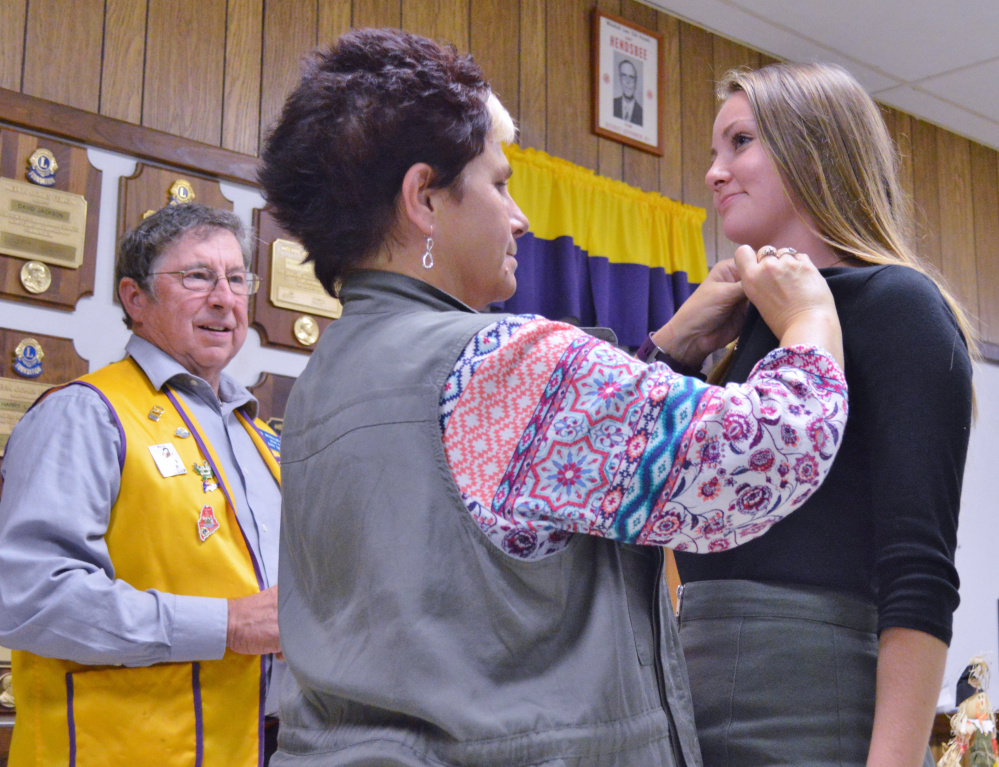 Leo Organizer Barry Tibbetts, left, looks on while Whitefield Lions Club President Cindy Lincoln pins new Leo Club member Parker King.