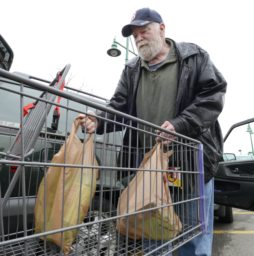 George Burnell of Portland loads plastic bags of groceries into his car at Portland's Hannaford Backbay store in April 2015 before a city ordinance went into effect to charge a nickel a bag. Members of the Sustain Mid Maine Coalition will be holding a cleanup on Tuesday, Halloween, to kick off their campaign to propose a ban on plastic bags in certain stores in Waterville.