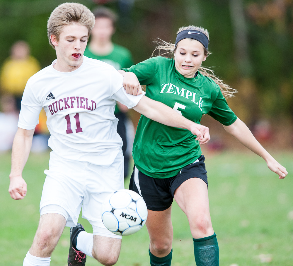 Sun Journal photo by Russ Dillingham 
 Buckfield's Noah Wiley (11) tries to get control of the ball as Temple's Julianna Hubbard pressures him during the first half of Tuesday's Class D South semifinal game in Buckfield.