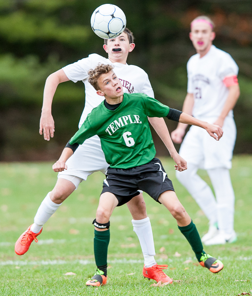 Sun Journal photo by Russ Dillingham 
 Temple's Nathan Riportella (6) and Buckfield's Kaleb Harvey battle for the ball during Tuesday afternoon's Class D South semifinal game in Buckfield.