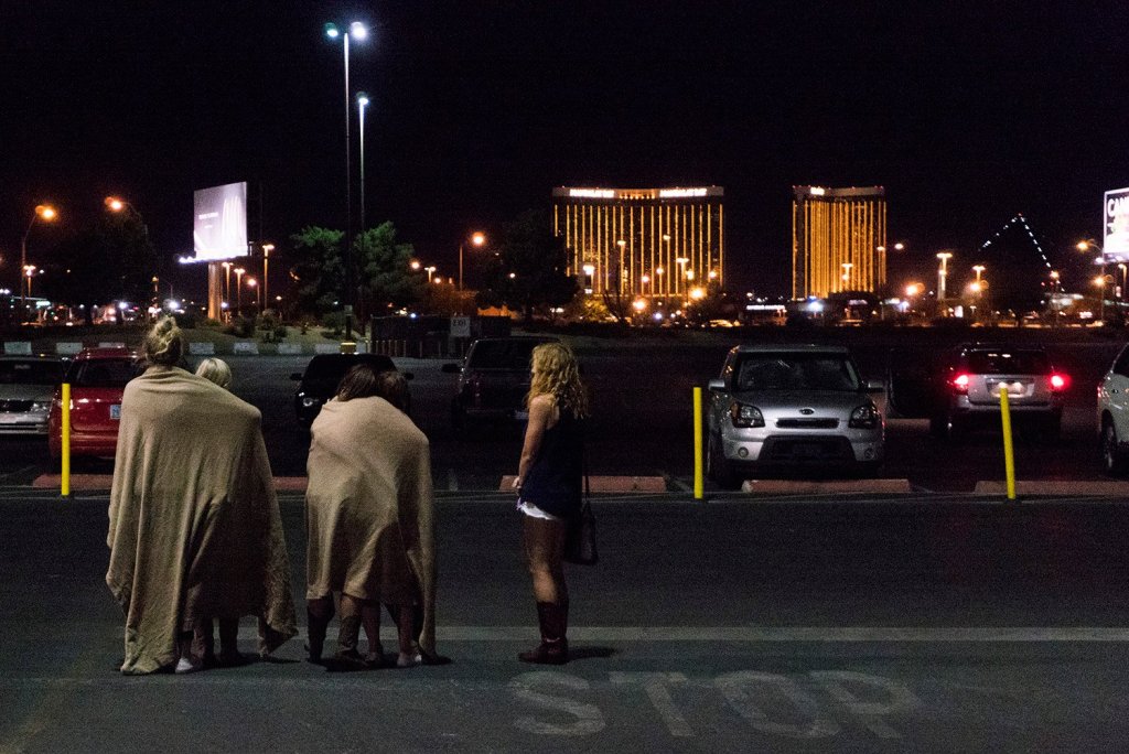 A group of women wait for their ride outside the Thomas & Mack center, which served as a refuge, following a mass shooting at the Route 91 music festival.