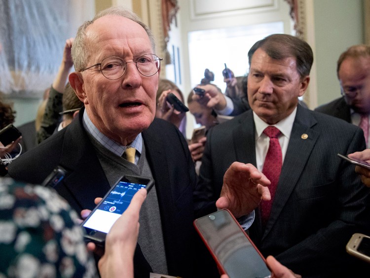 Sen. Lamar Alexander, R-Tenn., left, accompanied by Sen. Mike Rounds, R-S.D., speaks to reporters Tuesday after he and Sen. Patty Murray, D-Wash., said they have the "basic outlines" of a bipartisan deal to resume payments to health insurers that President Trump has blocked.