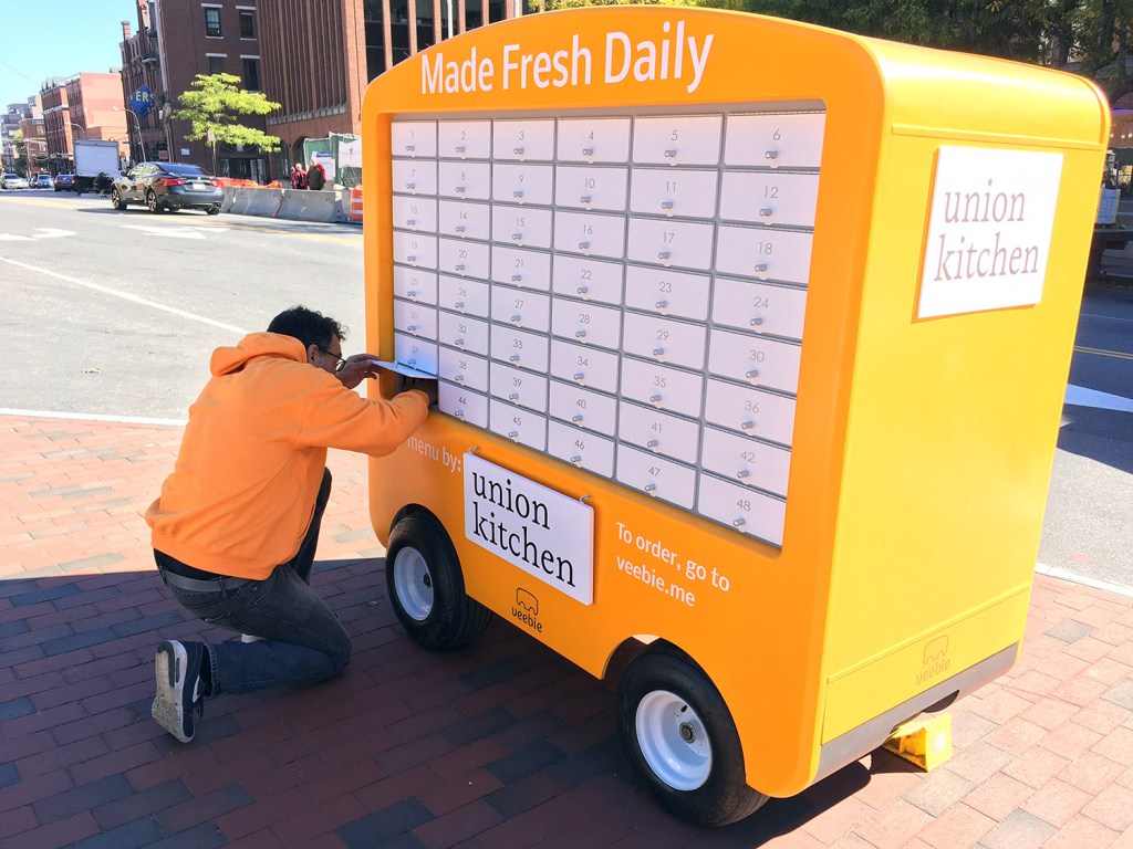 Yona Belfort, vice president of engineering at Veebie, Inc., stocks his company’s food cart with a prepared lunch from Union Kitchen.