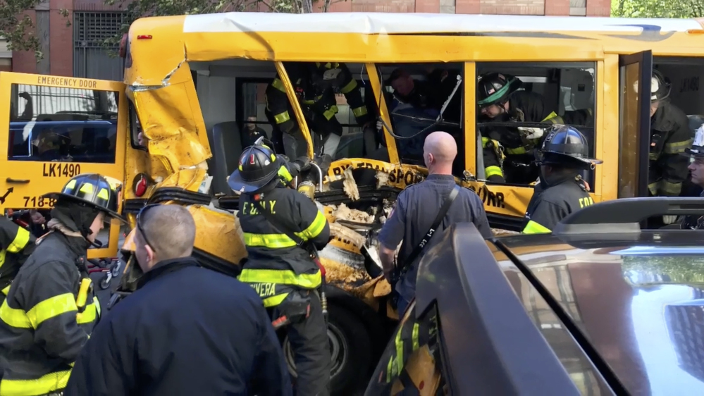 Emergency personnel work on a school bus after it was rammed by a driver in New York on Tuesday.